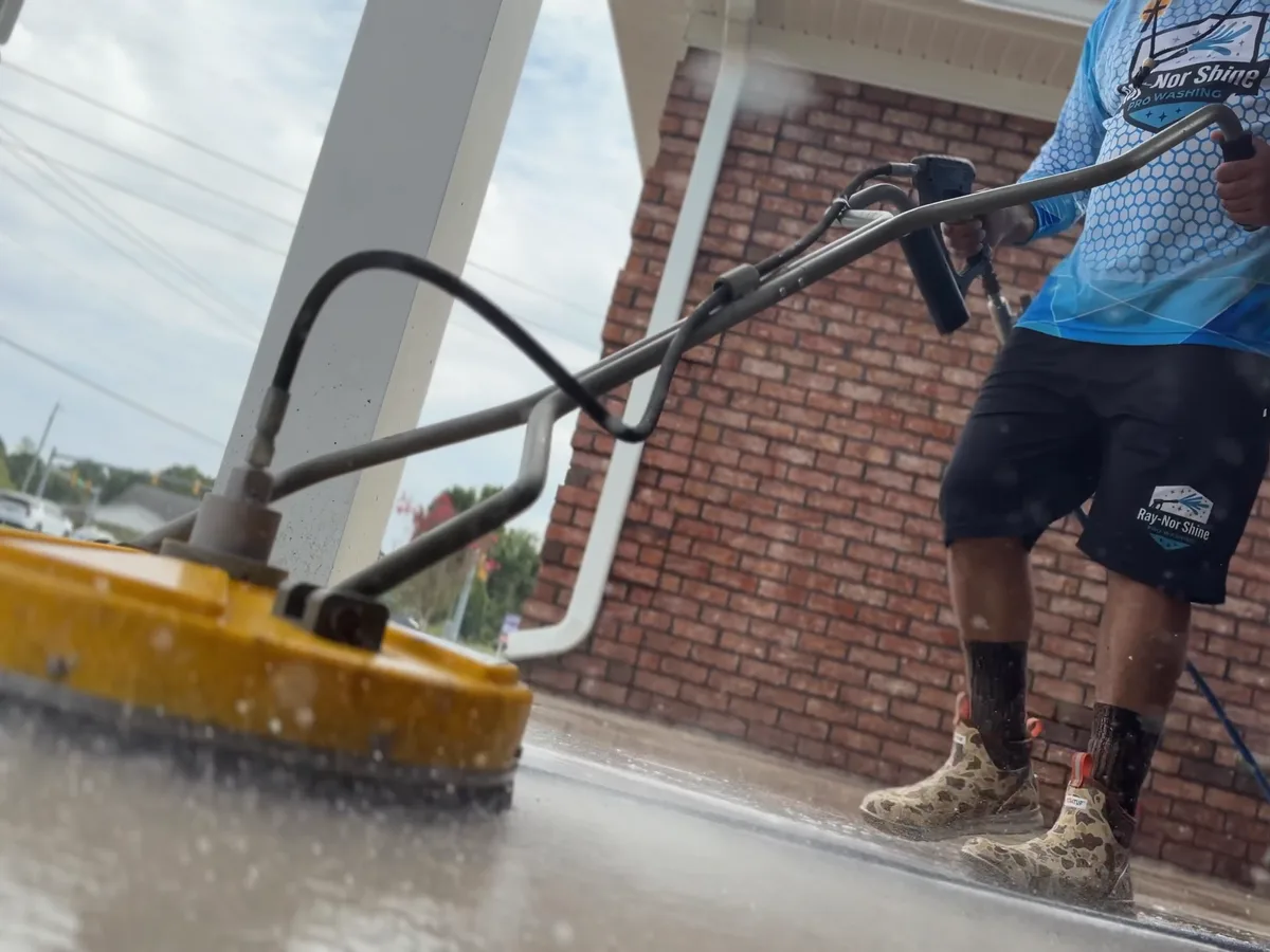 Eric Merritt of Ray-Nor-Shine Pro Wash running a rotary surface cleaner across concrete in Jacksonville NC