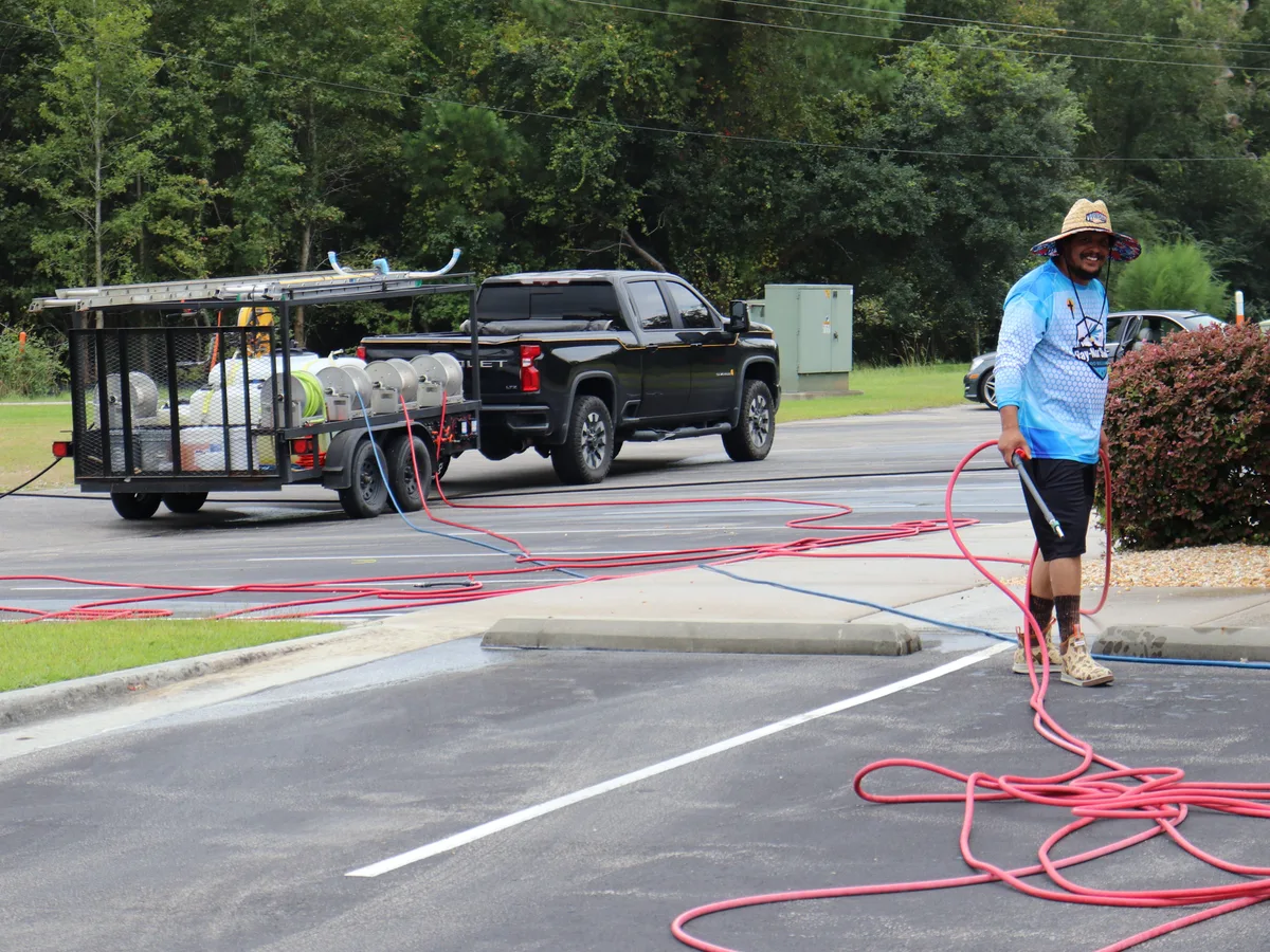 Eric Merritt of Ray-Nor-Shine Pro Wash beside the company truck and equipment trailer on a job in Jacksonville NC