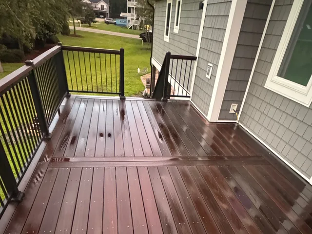 Freshly washed hardwood deck and black metal railing at a Jacksonville NC home