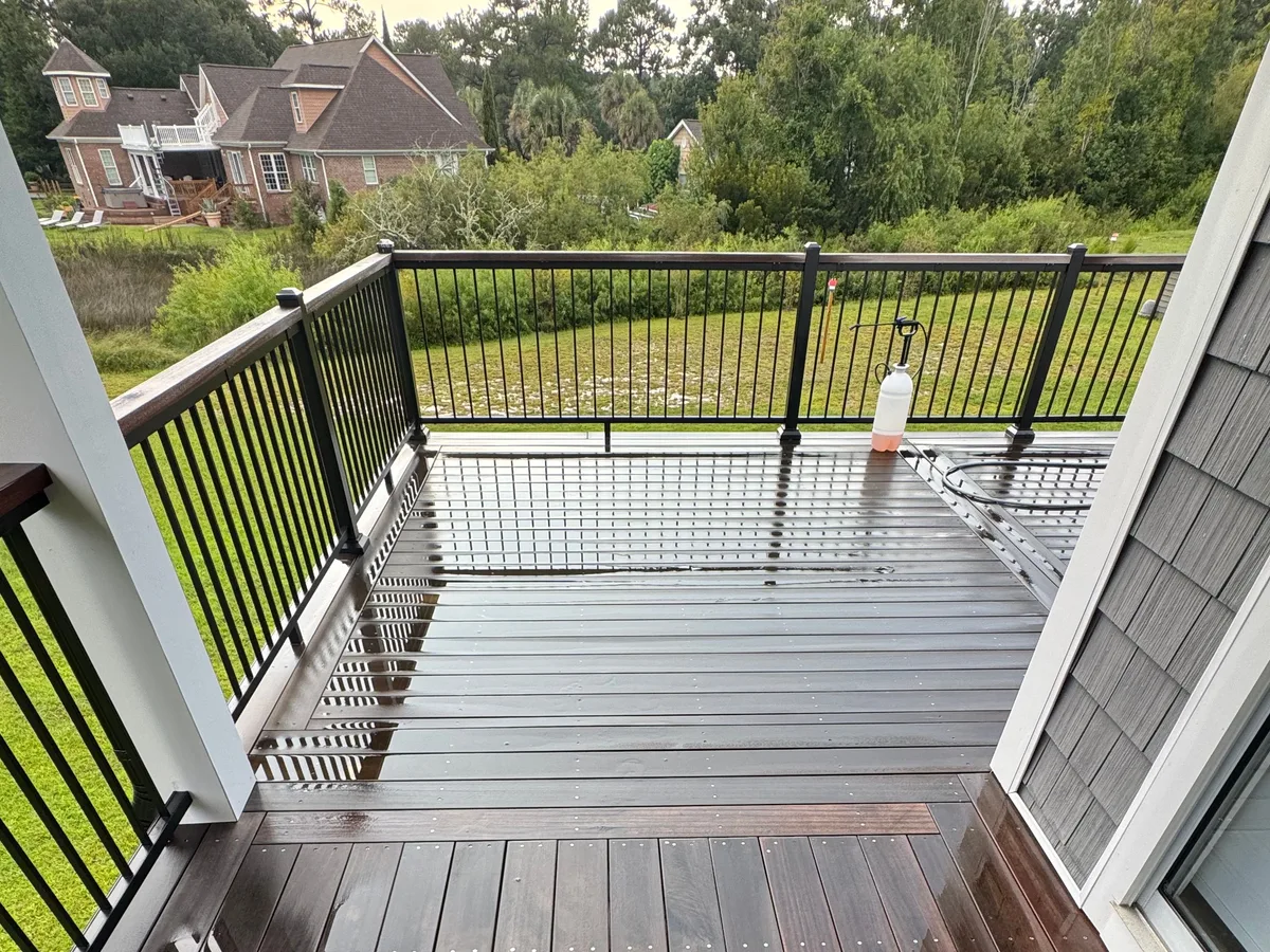Washing the corner of a raised hardwood deck with black metal railing in Jacksonville NC
