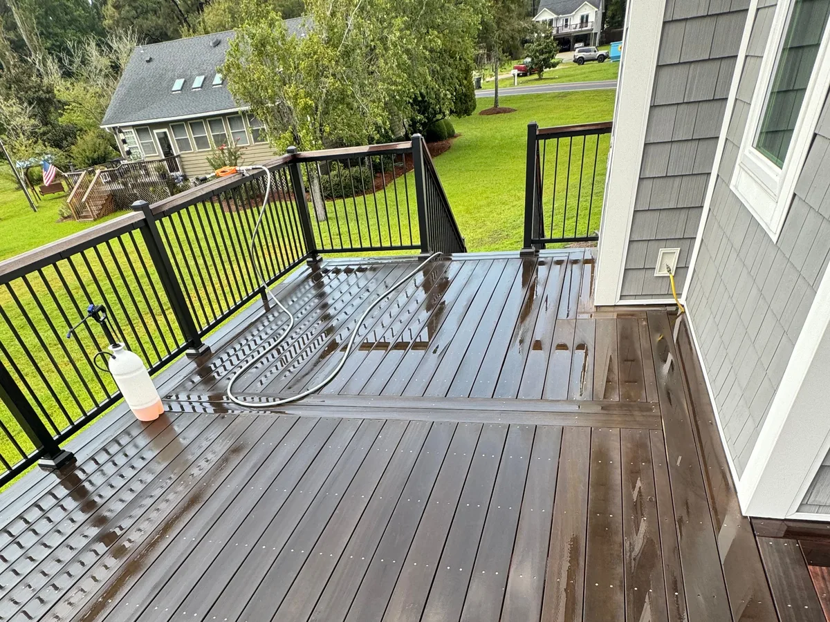 Deck cleaner being applied and worked across hardwood boards in Jacksonville NC