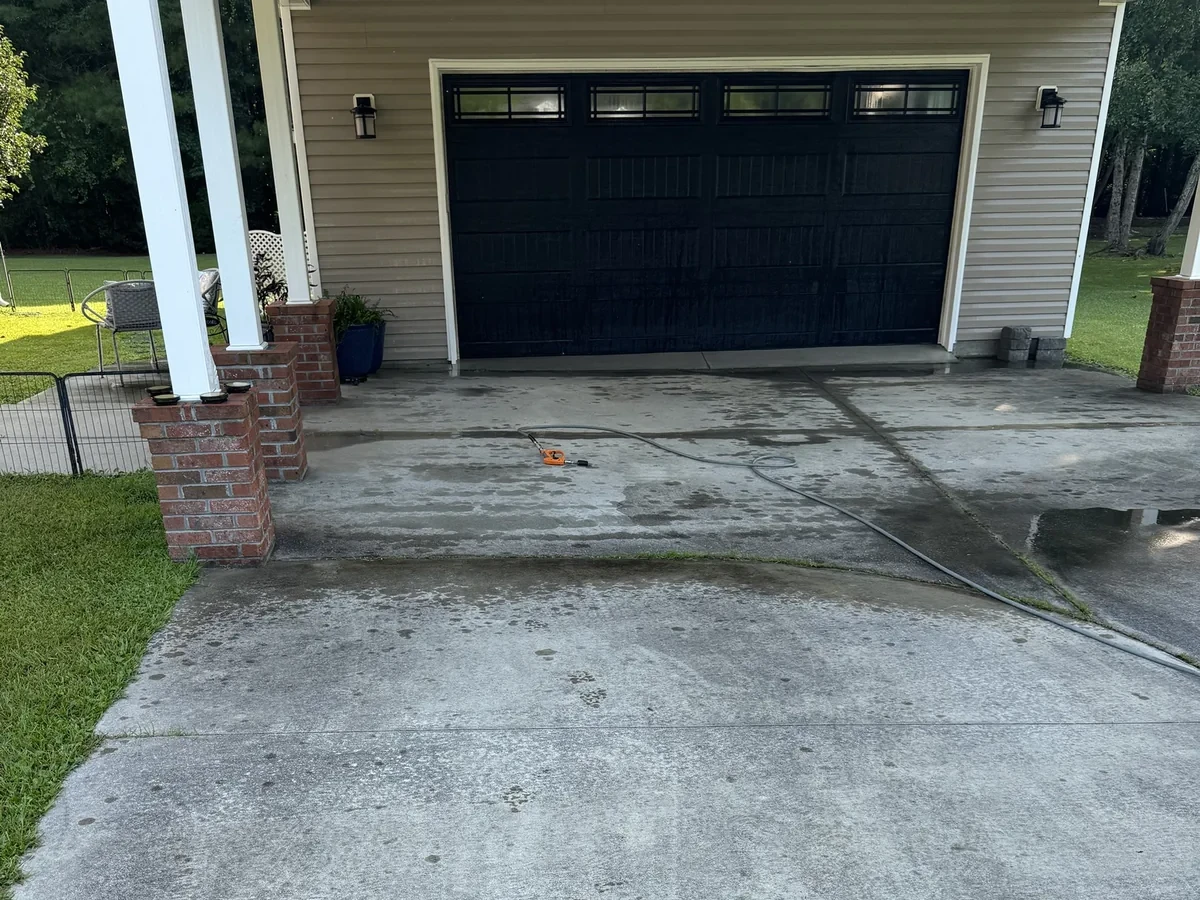 Algae-stained carport driveway before cleaning in Jacksonville NC